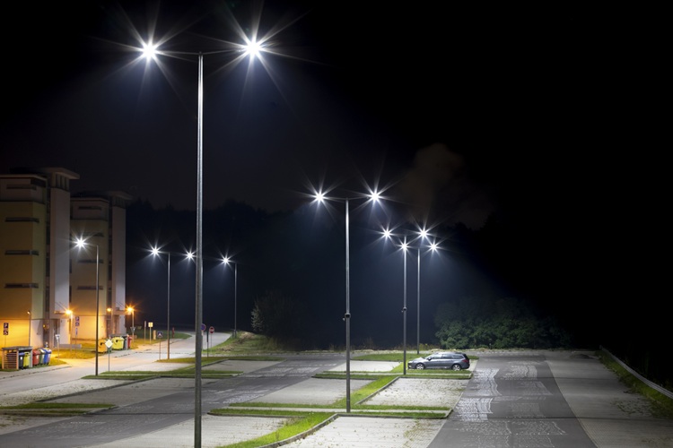 Well-lit parking lot with streetlights and illuminated spaces