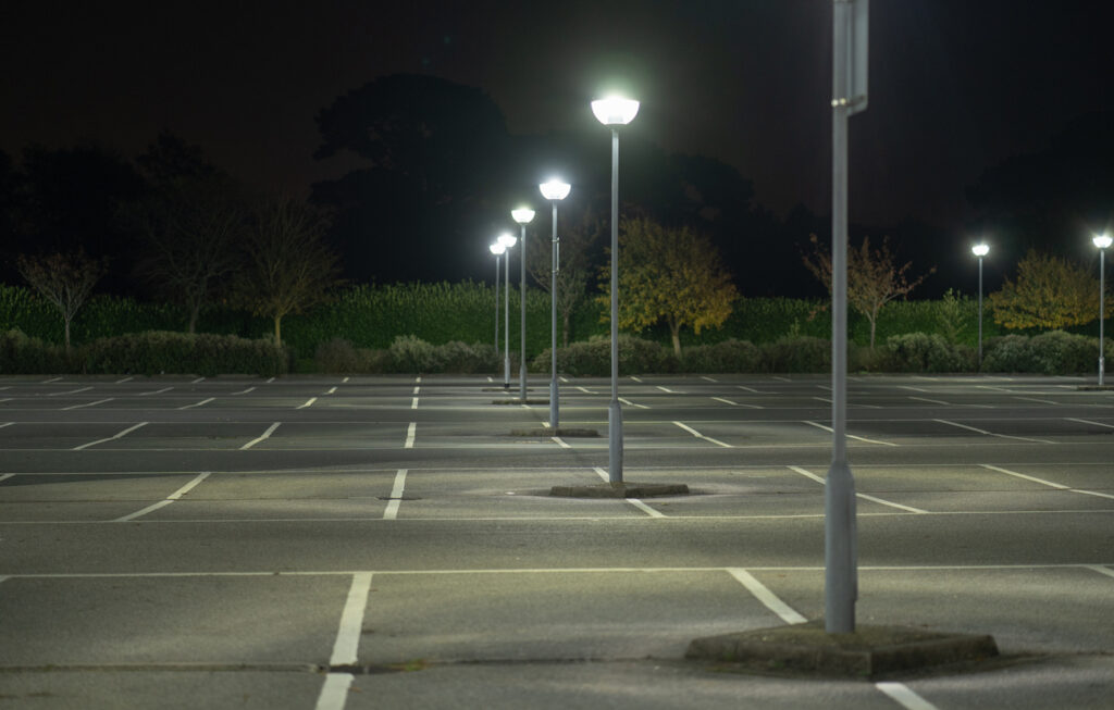 Well-lit empty parking lot at night with street lamps and clear markings