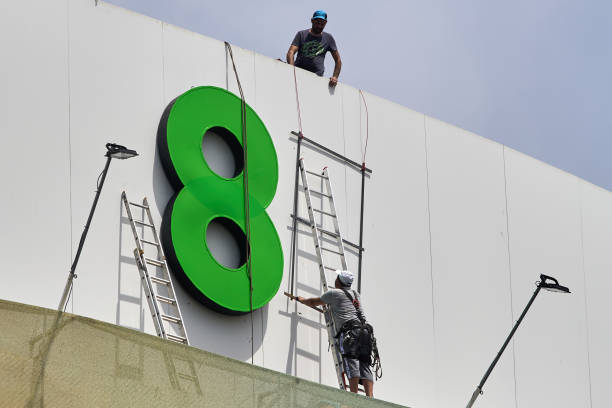 Workers setting up signage lighting for a large illuminated number